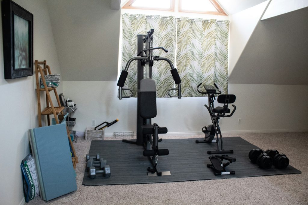 Home gym setup featuring beginner strength training for women equipment including adjustable dumbbells and bench