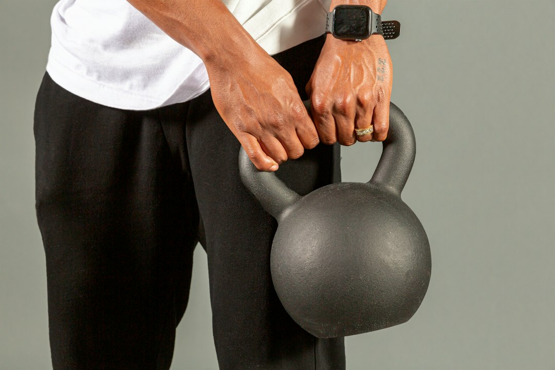 Adjustable vs Fixed Kettlebell: Space, Safety, and Cost Comparison 5 Close up view of hands performing a clean kettlebell swing hip hinge setup on gym floor