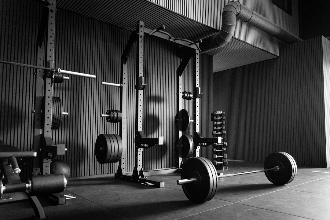 Athletic person preparing for deadlift on a dedicated home gym wooden platform.